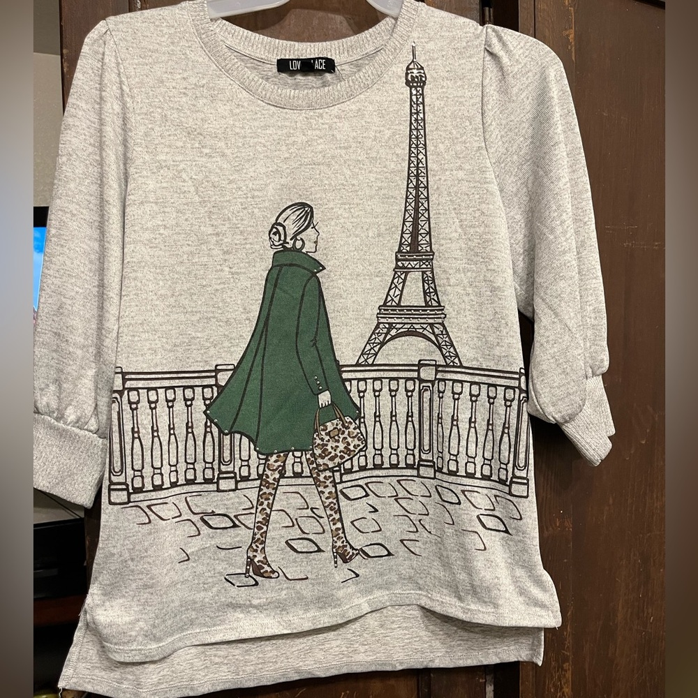 Love+Lust light gray shirt showing a girl in Paris looking at the tower.